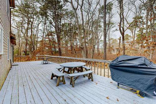 a wooden deck with a picnic table and a tent at Serene Cape Escape in Wellfleet