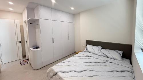 a bedroom with a large bed with white cabinets at Homestay Ninh Chữ in Thanh Hải