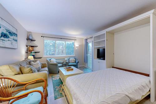 a bedroom with a bed and a couch and a tv at The Condo at Ocean Edge in Brewster