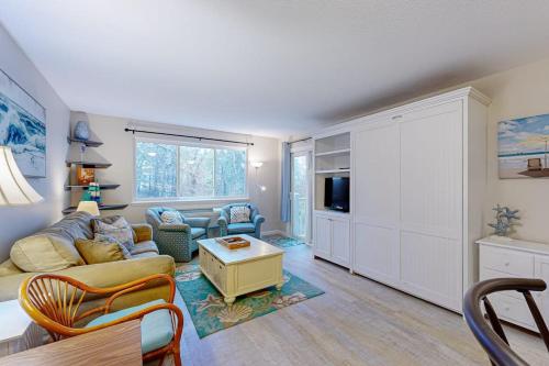 a living room with a couch and a tv at The Condo at Ocean Edge in Brewster
