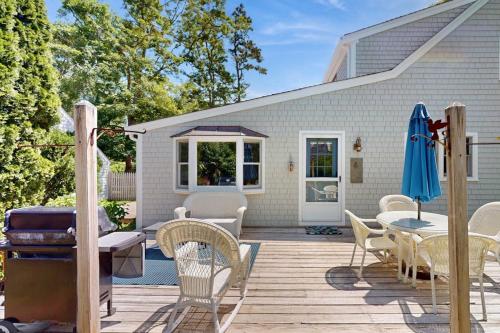 a patio with chairs and a table with an umbrella at Brewster Getaway in Brewster
