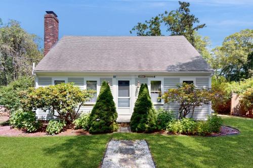 a white house with trees in the yard at Brewster Getaway in Brewster