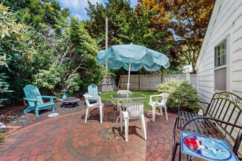 a patio with chairs and a table with an umbrella at Mermaid Cottage in Falmouth