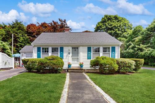 a small white house with blue shutters at Mermaid Cottage in Falmouth