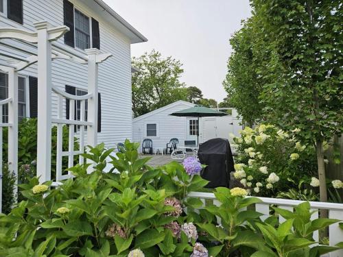 a white house with a white fence and some flowers at Edgartown Village in Edgartown