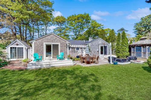 a house with a patio with a table and chairs at Miles Away in South Dennis