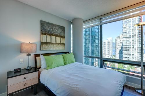 a bedroom with a bed and a large window at The Canadian in Vancouver