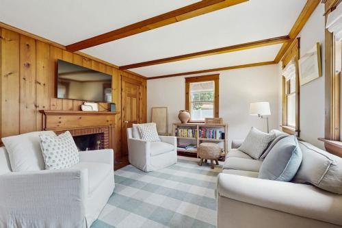 a living room with two white couches and a fireplace at The Cygnet in Falmouth