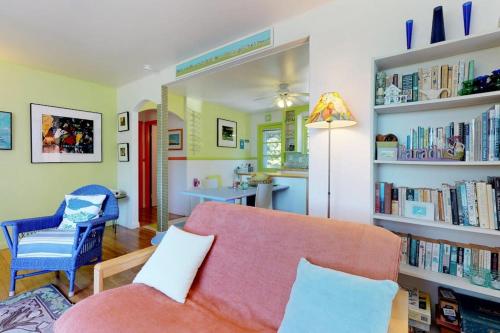 a living room with a pink couch and book shelves at Sunset Meadows in Oak Bluffs