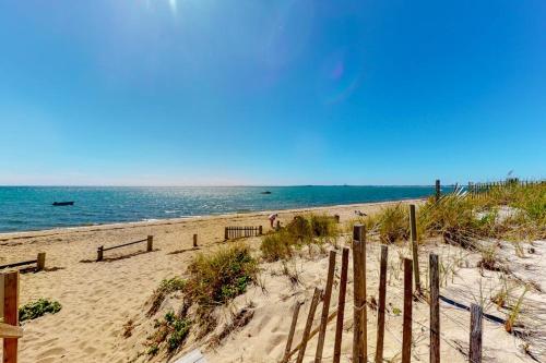 a sandy beach with a fence and the ocean at Sand & Beach Within Reach in North Truro