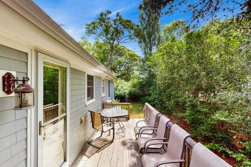 a deck with chairs and a table on a house at Winthrop Cottage in Oak Bluffs