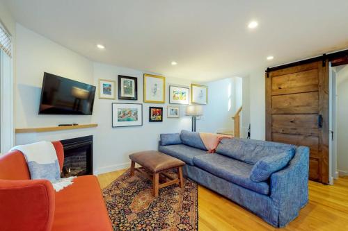 a living room with a blue couch and a fireplace at Summer Sun in Provincetown