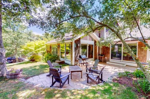 eine Terrasse mit Stühlen und einem Tisch vor einem Haus in der Unterkunft Hillside Oak in Chilmark
