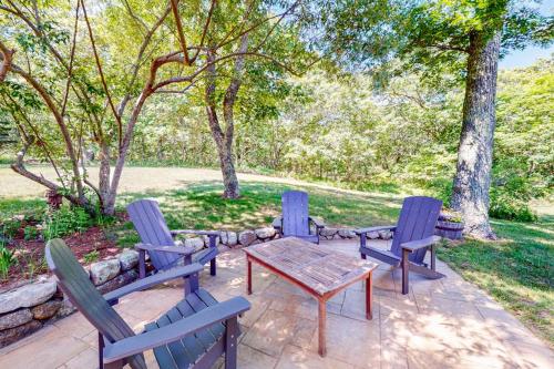 eine Terrasse mit Tisch und Stühlen und Bäumen in der Unterkunft Hillside Oak in Chilmark