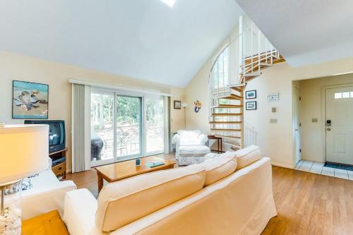 a living room with a white couch and a staircase at Relaxing Cape Getaway in Brewster