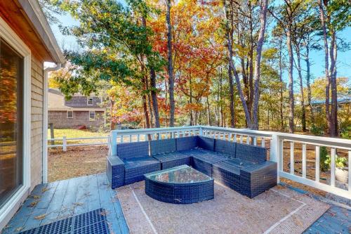 a blue bench sitting on a porch with trees at Sit Back & Relax in Eastham