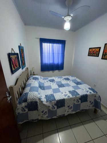 a bedroom with a blue and white quilt on a bed at Casa beira mar Jacaraipe. in Serra