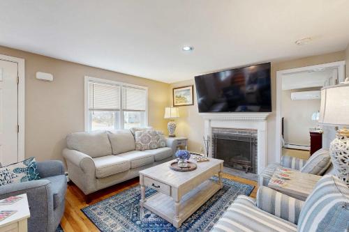 a living room with a couch and a fireplace at Cape Cod Playhouse in Yarmouth