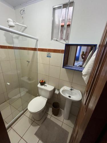 a bathroom with a toilet and a sink at Casa beira mar Jacaraipe. in Serra