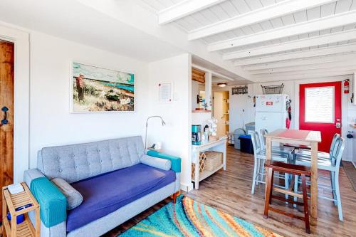 a living room with a blue couch and a kitchen at Dunes Edge in Wellfleet