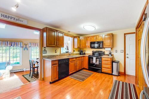 a kitchen with wooden cabinets and black appliances at Mattakeese Villa in Yarmouth