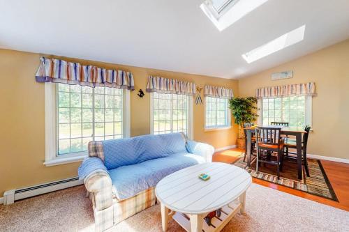 a living room with a blue couch and a table at Mattakeese Villa in Yarmouth