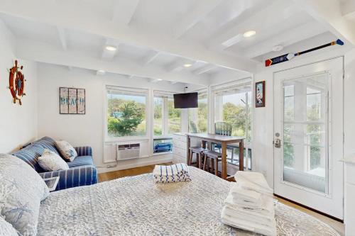 a living room with a bed and a couch and windows at Ships Ahoy in Truro