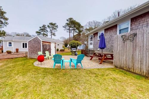 a backyard with chairs and a table and a picnic table at Anchors Await in South Yarmouth