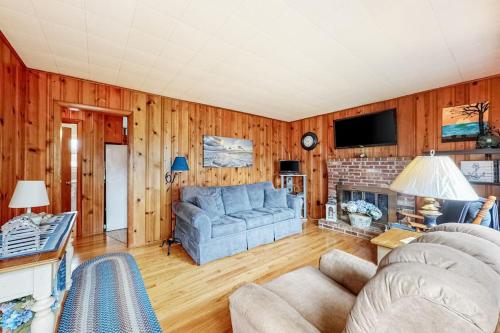 a living room with a blue couch and a fireplace at Anchors Await in South Yarmouth