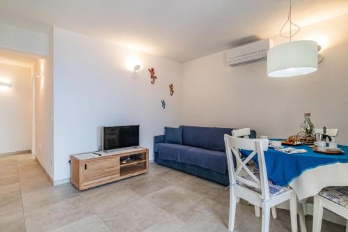 a living room with a blue couch and a table at Tra il Borgo e il Mare - Bel Horizonte in Capoliveri