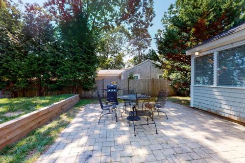 a patio with a table and chairs in a backyard at Sweet Victory in Harwich Port