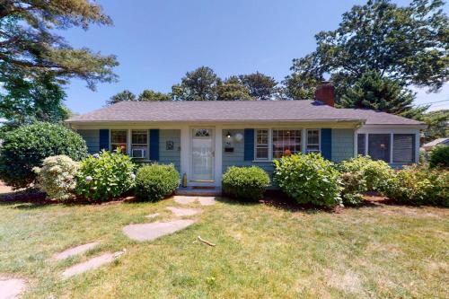 a blue house with bushes in a yard at Sweet Victory in Harwich Port