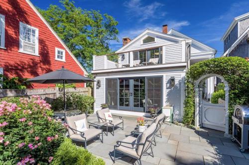 a patio with chairs and an umbrella in front of a house at The Long Fox in Provincetown