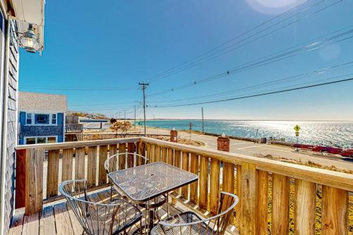 a balcony with a table and chairs and the beach at Bay Colony Vista in Provincetown