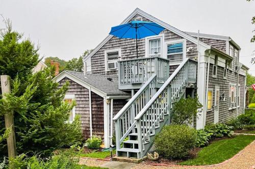 a house with a staircase with an umbrella on it at Everyday is Saturday in Vineyard Haven