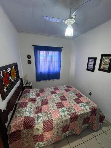 a bedroom with a bed with a quilt on it at Casa quadra praia Jacaraipe! in Jacaraípe