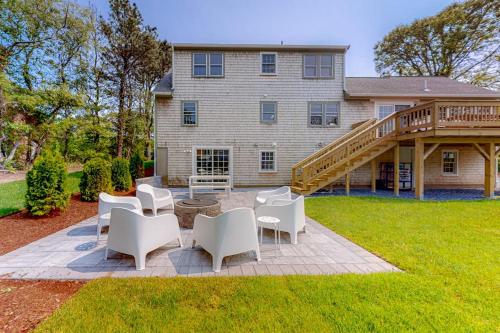 a patio in front of a house with white chairs at New England Getaway in Dennis