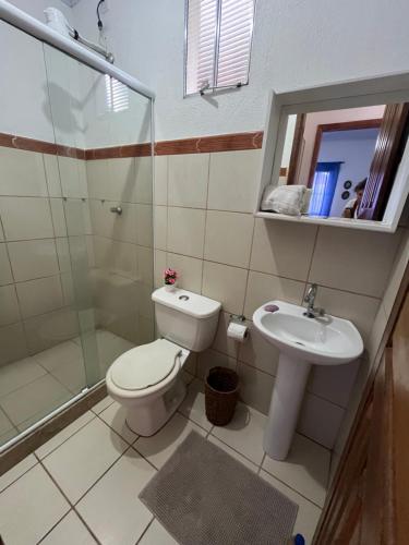 a bathroom with a toilet and a sink at Casa quadra praia Jacaraipe! in Jacaraípe