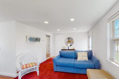a living room with a blue couch and a chair at Adventures on Buzzards Bay in Bourne