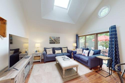 a living room with blue couches and a table at South Cape Escape in Mashpee