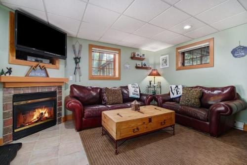 a living room with leather couches and a fireplace at Boyne Mountain Getaway, Unit B in Boyne Falls