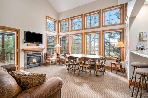 a living room with a table and a fireplace at Boyne Mountain Getaway in Boyne Falls
