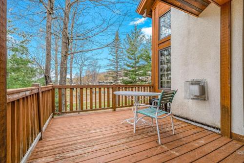 a wooden deck with a table and chairs on it at Boyne Mountain Getaway in Boyne Falls