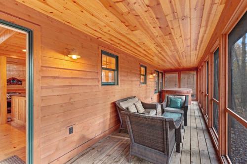 a screened porch with a couch and chairs at Kingfisher Cove Cabin 28 in Saugatuck
