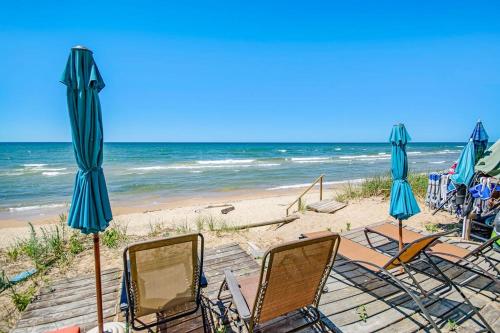 a group of chairs and umbrellas on a beach at Jacobia Lakefront Retreat in Covert