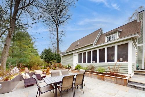 a patio with a table and chairs in front of a house at Seaglass Lakeshore Cottage in Union Pier