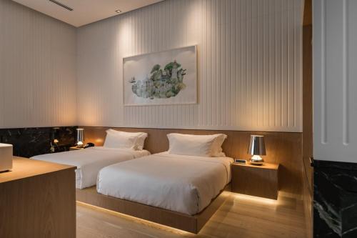 two beds in a hotel room with two lamps at Macalister Mansion, a Member of Design Hotels in George Town