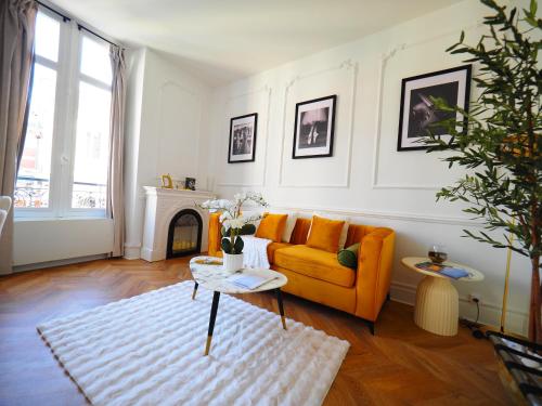 a living room with an orange couch and a white rug at NOUVEAUTE JUILLET 2026 Le BALCON DE L OPERA in Vichy