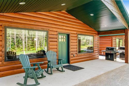 a cabin with two chairs and a table and a grill at The Eagle in Conover