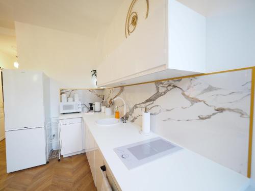 a kitchen with white counters and a white refrigerator at NOUVEAUTE JUILLET 2026 Le BALCON DE L OPERA in Vichy